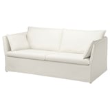 A white BACKSÄLEN sofa. It has a minimalist design with clean lines and plush cushions. The fabric is a soft, machine-washable cotton blend.