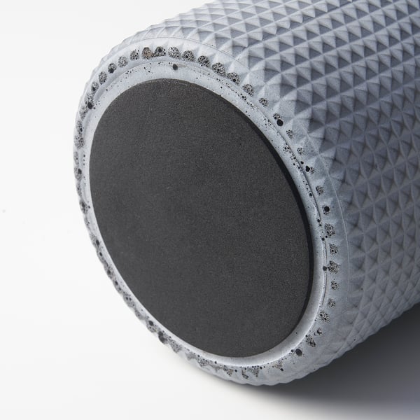 Cylindrical grey concrete planter with diamond-textured surface and felt bottom, resting on white background.