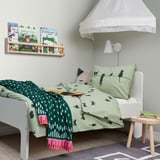 Childs room with BARNDRÖM cat duvet, bookshelf, and nightstand.