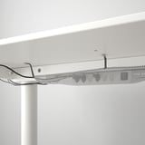 A white desk with a cable management net underneath, supporting adjustable height functions.