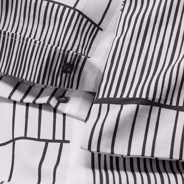 Close-up of striped duvet cover with press-stud closure, showcasing its minimalistic design and crisp fabric.