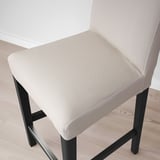 Chic bar stool with beige cushion, black metal legs, and ergonomic design. Comfortable and stylish for modern dining.