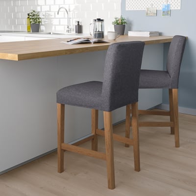 Two BERGMUND bar stools by kitchen island with coffee maker. Sleek, cushioned, removable covers.