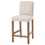 The BERGMUND bar stool is beige with light wood legs. It a cushioned seat and back, and a simple, sleek design.