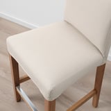 Beige barstool with wooden legs, showcasing high-quality upholstery and sturdy construction.