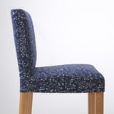 Stylish bar stool with dark blue floral fabric, cushioned seat, wooden legs.