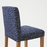 A navy blue bar stool with floral pattern and wooden legs; sturdy, comfortable, and stylish.