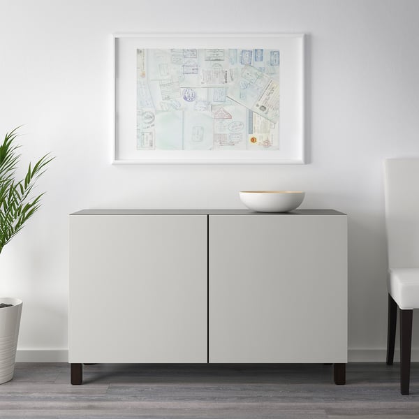 White sideboard with dark legs, art, bowl