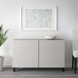 White sideboard with dark legs, art, bowl