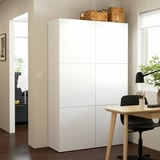 White BESTÅ cabinet in minimalist room with desk, basket.
