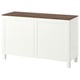 A white BESTÅ sideboard with wooden top. It adjustable shelves, a push-open or soft-close hinge option, and sturdy legs. Simple and functional design.