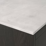 Close-up of sleek, light grey countertop with subtle texture over dark cabinet, showcasing premium materials.
