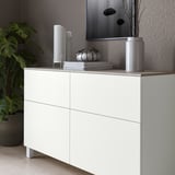 White BESTÅ cabinet with light grey top panel, displaying decorative items.