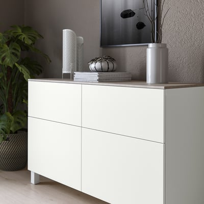 White BESTÅ cabinet with light grey top panel, displaying decorative items.