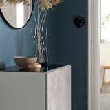 A BESTÅ glass top panel in blue, rectangular, with a modern design, is large and sits atop a cabinet, holding decorative items.