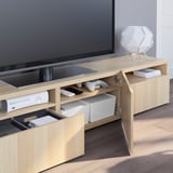 Wood tv stand with open drawers for controllers & storage, lamp, cable management on wooden floors.