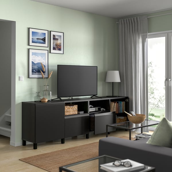 Green living room with tv, plants, & natural light.