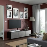 Modern living room with BESTÅ tv bench, gray walls, photos, tall lamp, and large window.