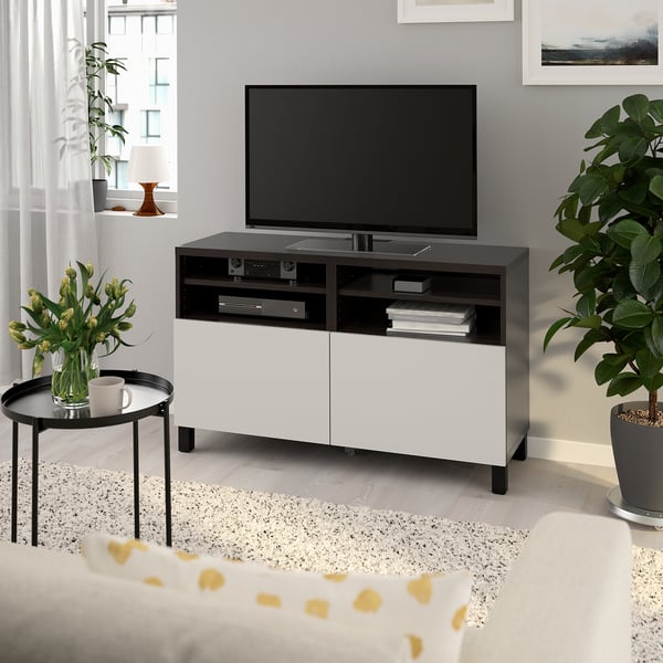 Modern black & white living room with BESTÅ tv bench, plants, and natural light.