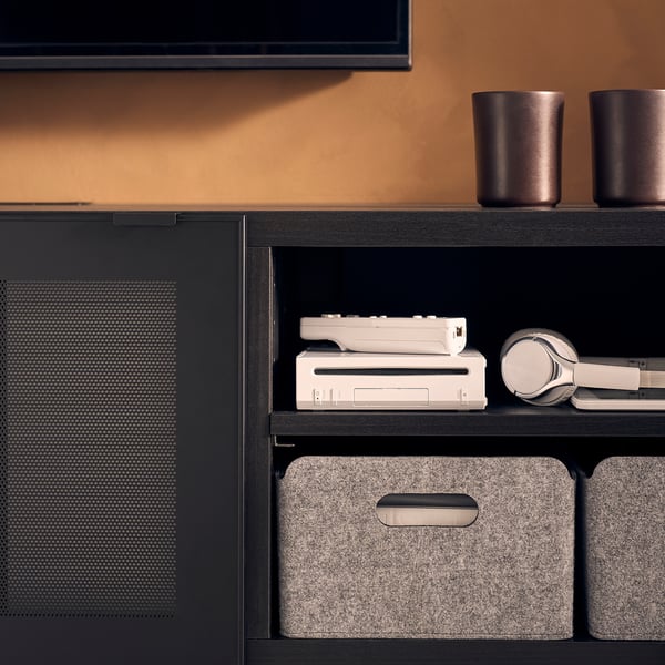 Black BESTÅ tv bench with adjustable shelves and gray felt storage boxes.