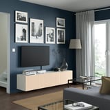 Modern living room: BESTÅ tv bench, art wall, glass table, rug, window.
