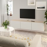 Modern living room with BESTÅ, flat screen, and yellow sofa. Bright decor with clean lines.