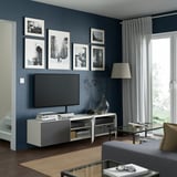 Modern living room with flat-screen tv, adjustable shelves, cable management, and wall-mounted stand.