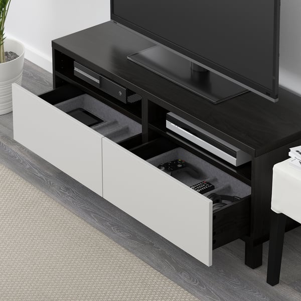 Modern black tv stand with two open drawers, housing gaming controllers and remote. Cable management and soft-close drawers.