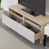 Wood tv stand with remote and controller in drawer, flat screen tv, dvd, soundbar, white wall.