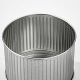 Silver metal trash can with vertical ridges.