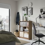 Cozy bedroom with BILLY bookcase, home office setup, green bed, city view.