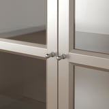 Close-up of sleek, metallic cabinet hinge, quality evident in detailed craftsmanship.