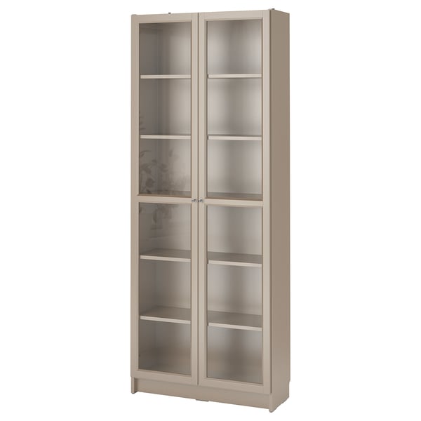 A BILLY bookcase, beige in color, with glass doors and adjustable shelves for storage.