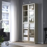 BILLY white bookcase with glass doors next to window.