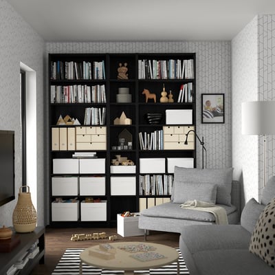 Black BILLY bookcase with extensive storage, gray couch, large tv.