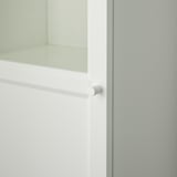 This image shows a close-up of a white cabinet door with a handle, highlighting the sleek and modern design.