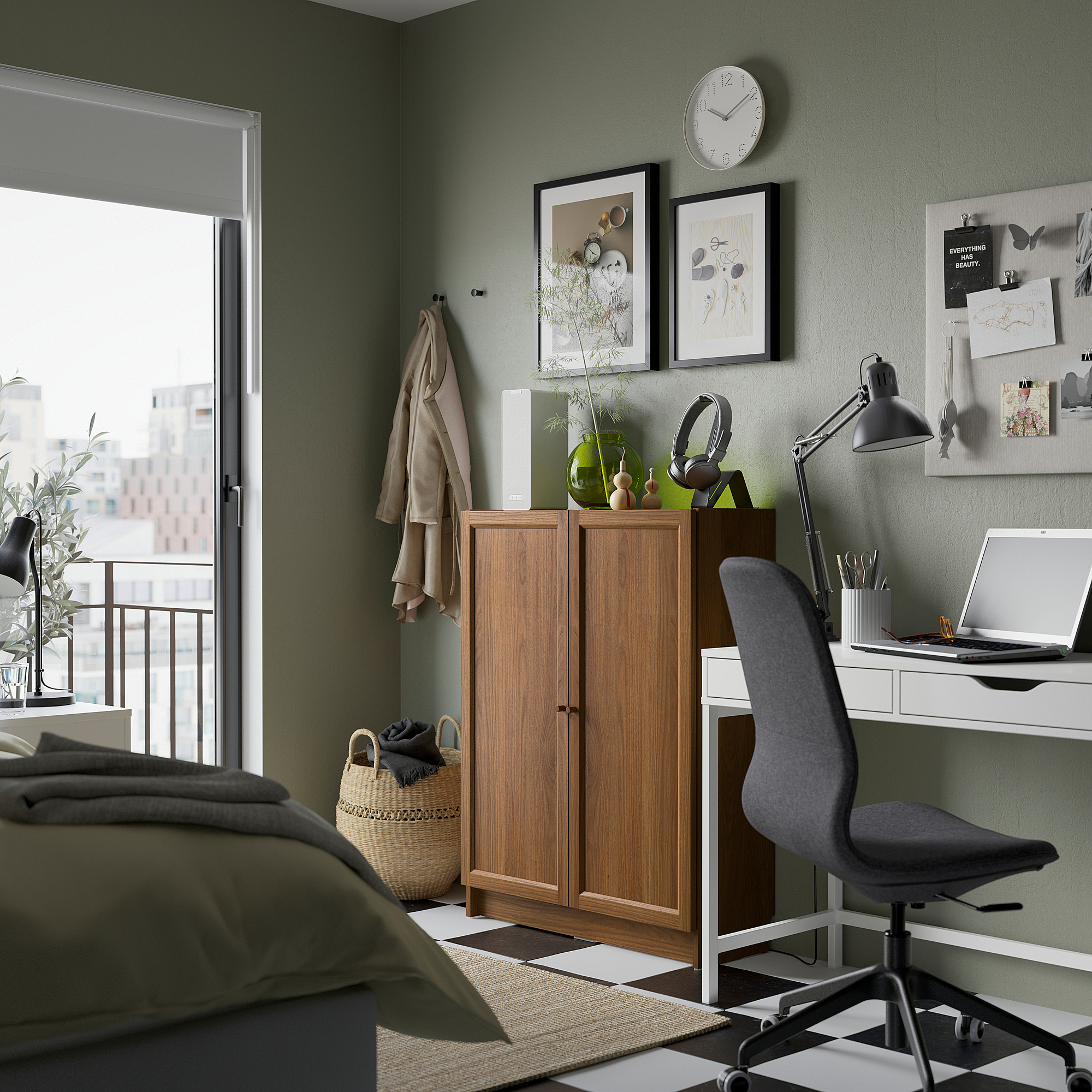 Cozy bedroom with BILLY bookcase, desk, chair, olive-green bed sheets, and green wall with art and clock.
