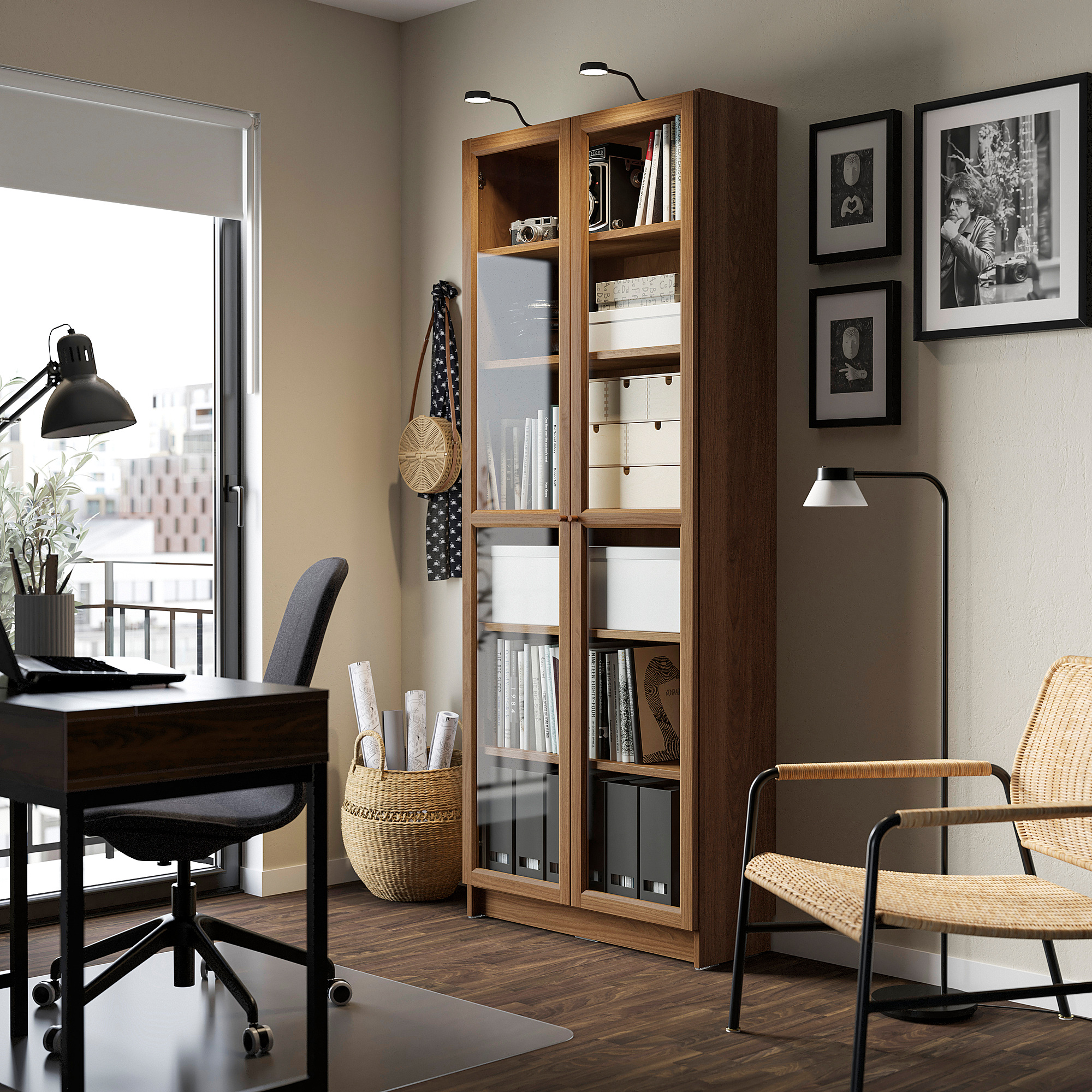 Modern office with BILLY bookcase, glass doors, wicker chair, glass desk, and photo wall.