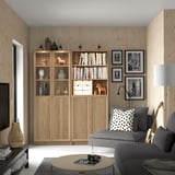 Living room with BILLY bookcases, gray sofa, and round coffee table.