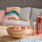 Bamboo bowl with candies on table near couch.