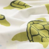 Duvet cover with soft, detailed green turtle prints on white cotton, showing quality stitching and design.