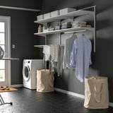 BOAXEL wall storage in laundry room with drying rack, clothes, and bags.