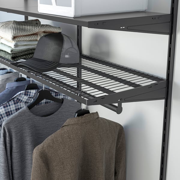 Closet with dark shelves, hanging shirts, jacket, and folded clothes, showing organized storage.