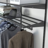 Closet with dark shelves, hanging shirts, jacket, and folded clothes, showing organized storage.