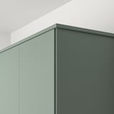 Close-up of modern grey-green kitchen cabinet edges, showcasing sleek design with smooth finishes.