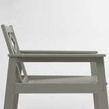 Gray outdoor wooden chair with metal legs and a slatted seat, shown from the side.