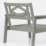 A grey outdoor armchair with intricate, durable wooden design. Sturdy legs and slatted seating, showcasing quality craftsmanship.