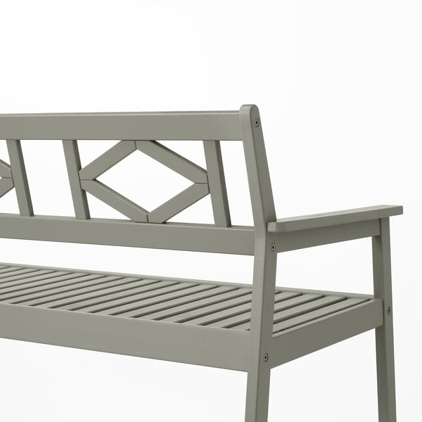 Light grey outdoor bench with intricate back design, sturdy eucalyptus wood, slatted seat, and armrests, ideal for comfort and durability.