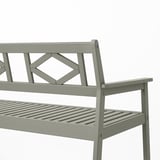 Light grey outdoor bench with intricate back design, sturdy eucalyptus wood, slatted seat, and armrests, ideal for comfort and durability.
