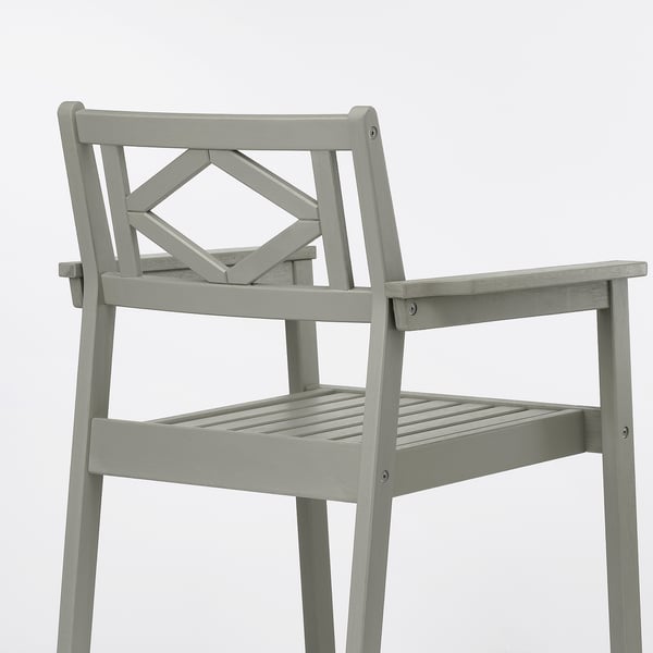 Displays a high-quality, grey outdoor chair made of durable eucalyptus. It a traditional style with handicraft details and plastic feet for stability.